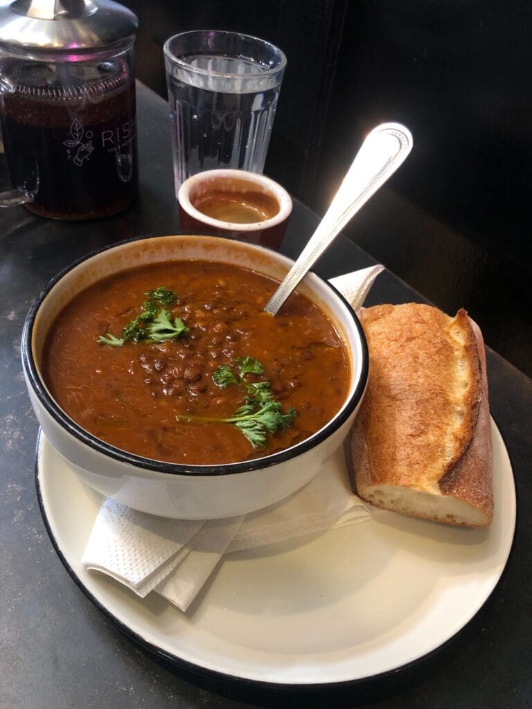 a bowl of soup and a sandwich on a plate