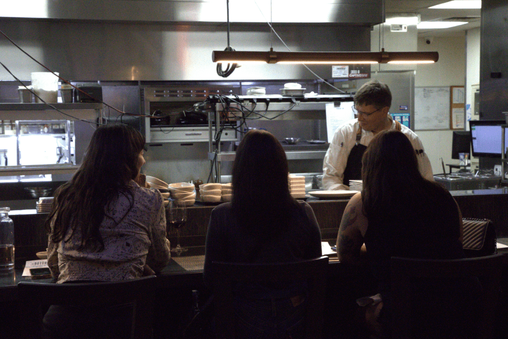 a group of people standing in a kitchen