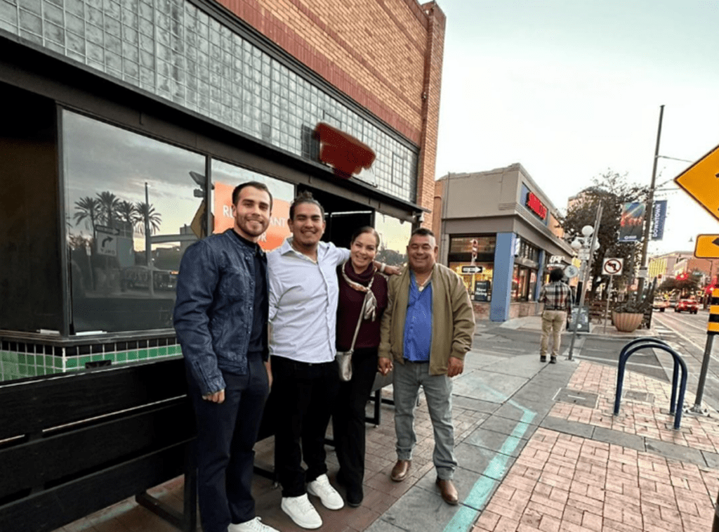 a group of people standing on a sidewalk