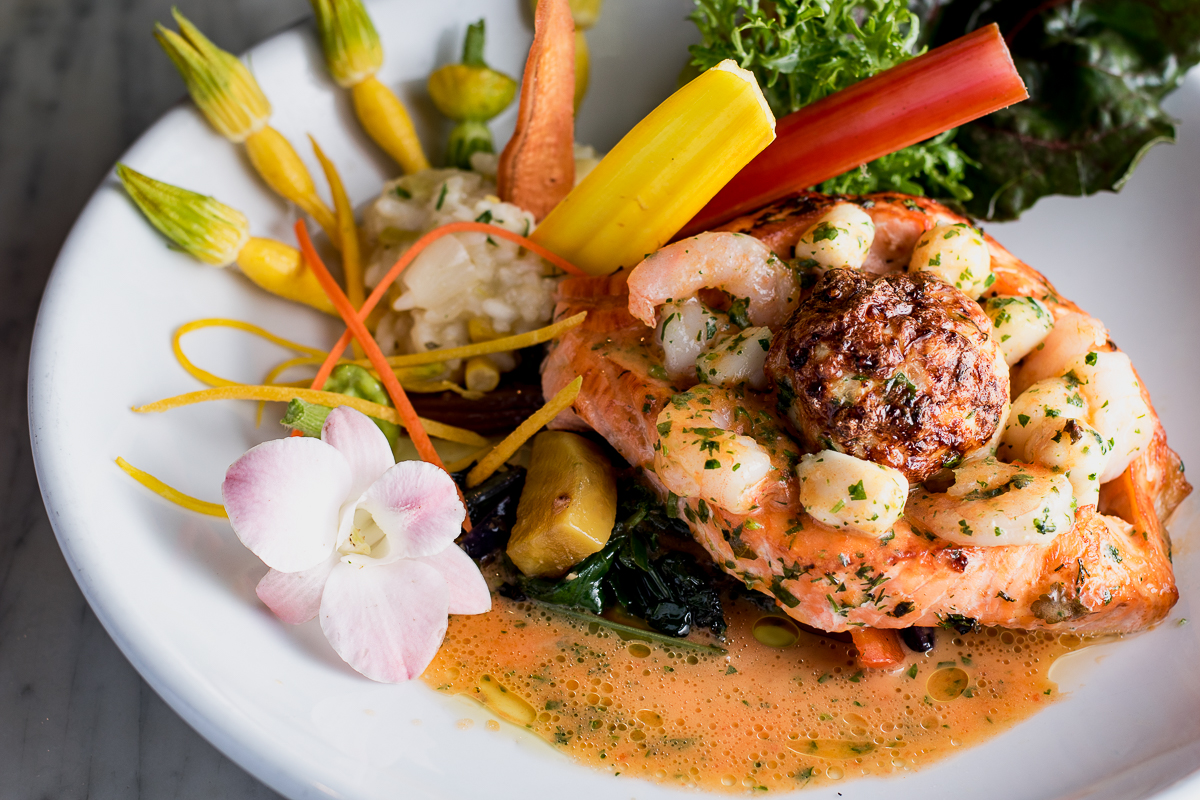 Scottish salmon fillet stuffed with shrimp, scallops, crab soufflé, and basil red pepper beurre blanc at Wild Garlic Grill