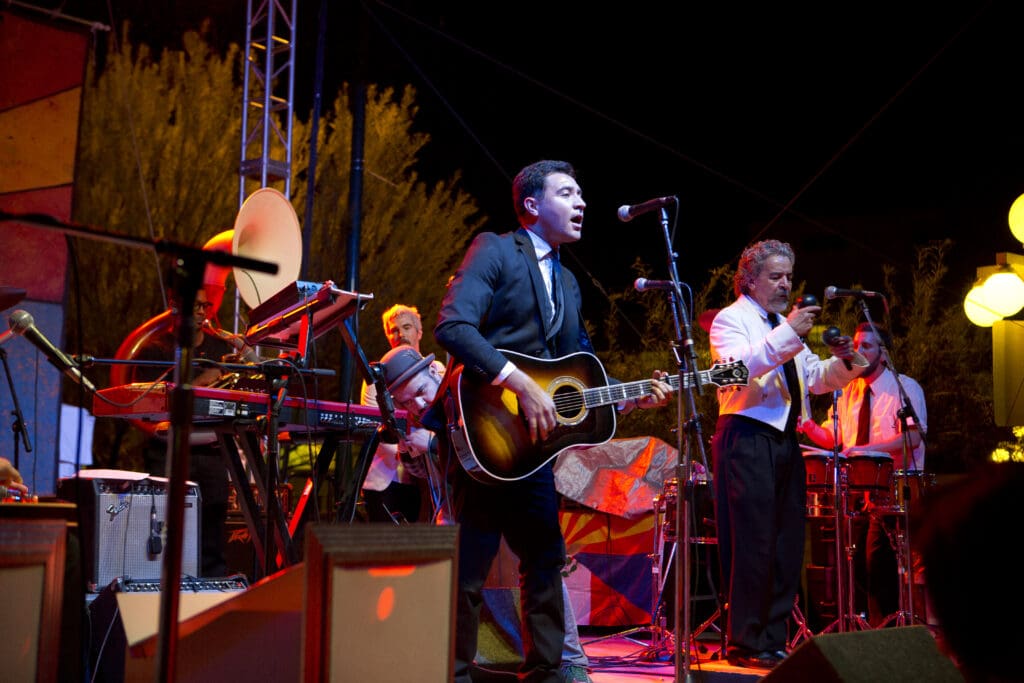 a group of people playing instruments and performing on a stage