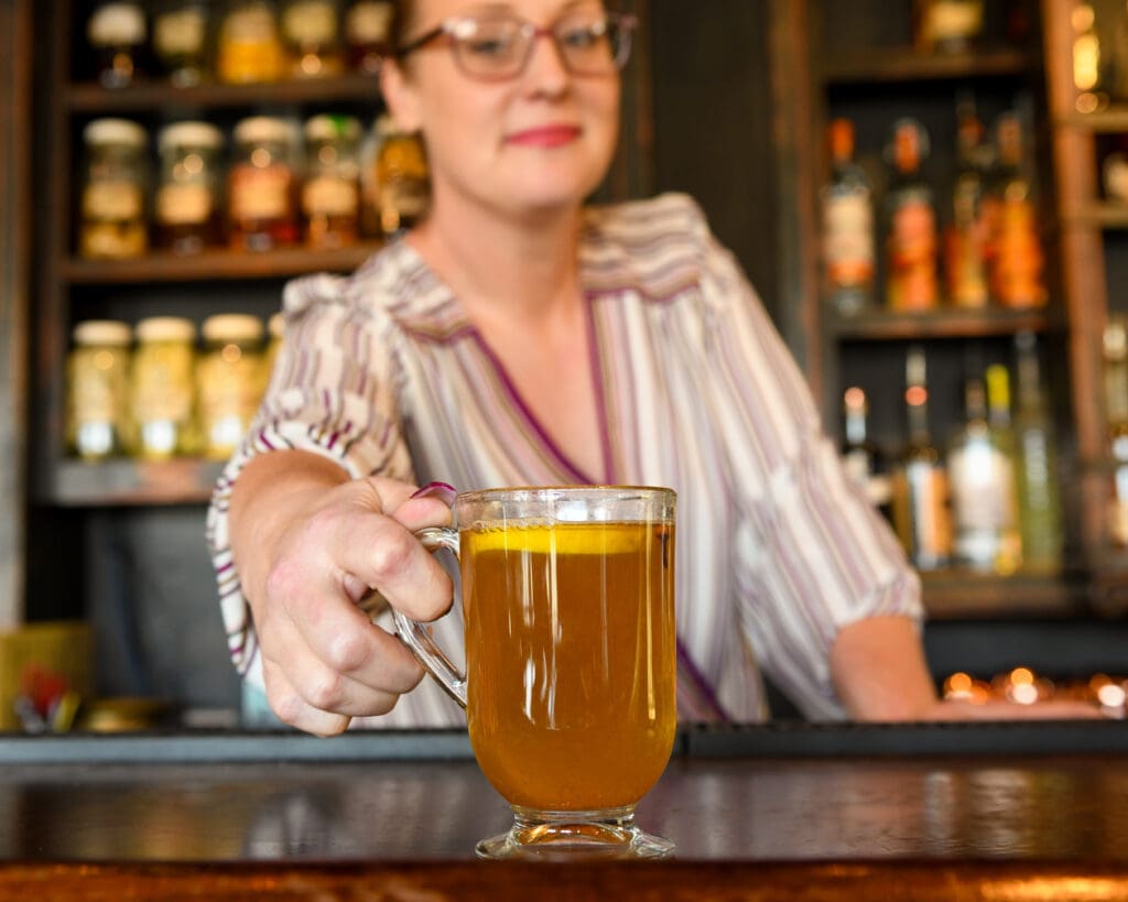 a person sitting at a table with wine glasses